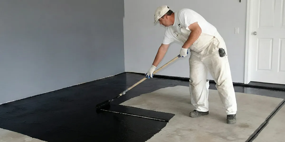basement waterproofing professional applying waterproof coating to protect a basement floor in Glendale, AZ