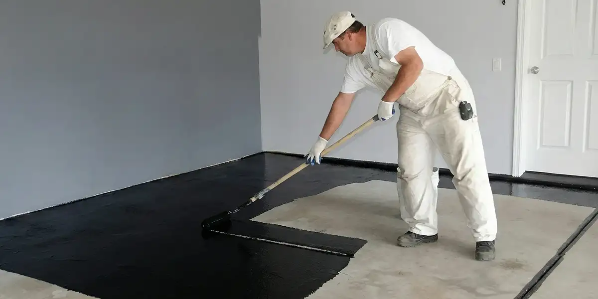basement waterproofing professional applying waterproof coating to protect a basement floor in Glendale, AZ